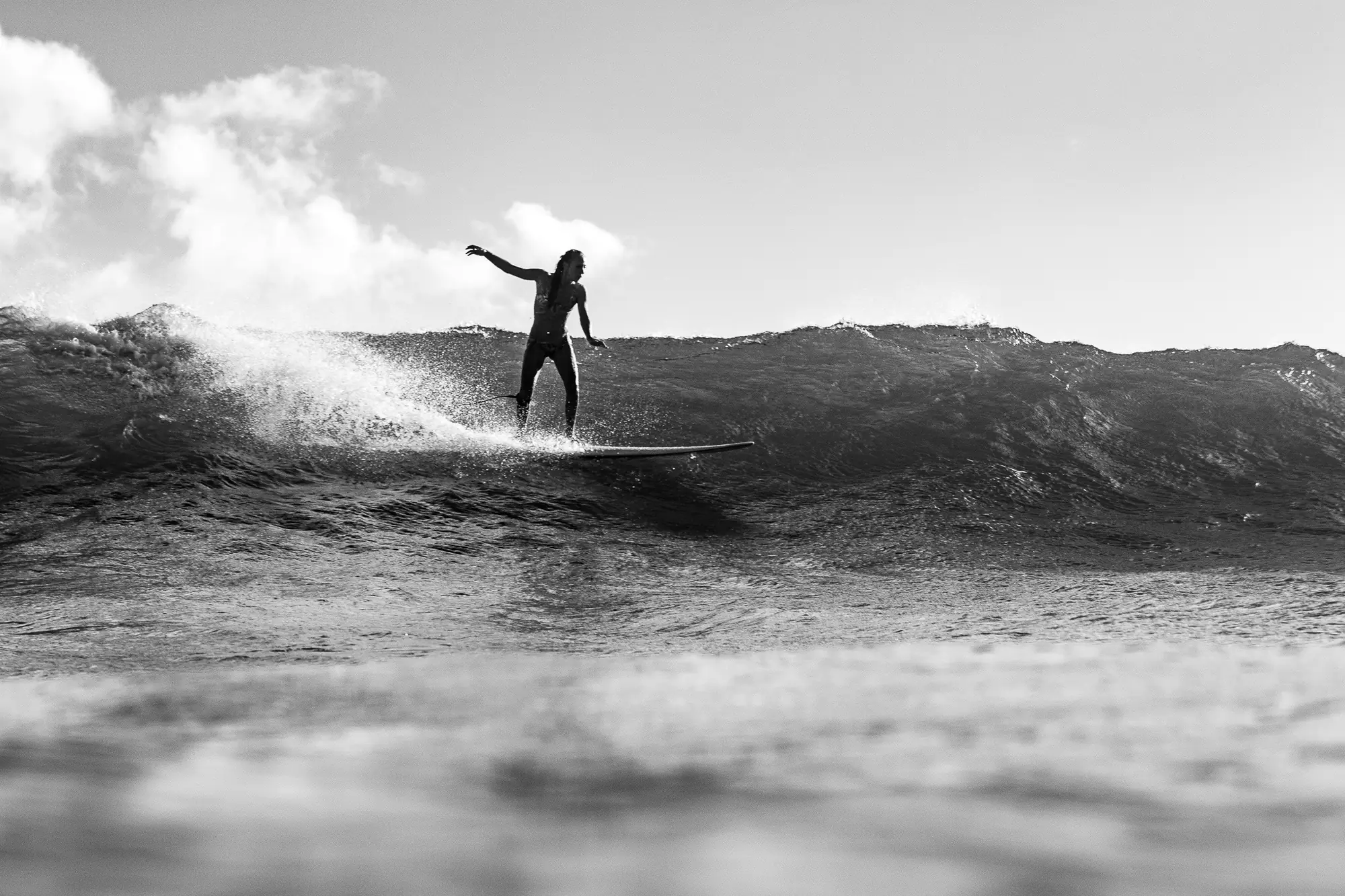 Surfer riding a wave in black and white